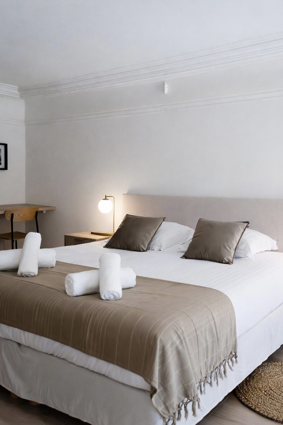 Chambre soignée avec linge de lit et serviettes roulées